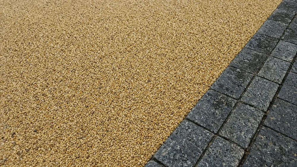 Example image: close-up of a resin-bound stone surface beside metal edging