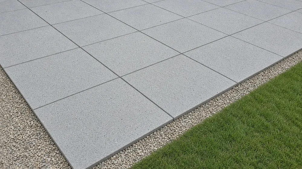 Example image: slabs being bedded on a full mortar bed over a compacted stone sub-base
